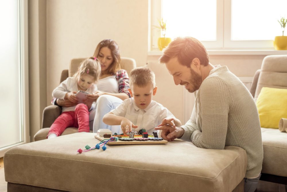 A shallow focus shot of a happy Caucasian family reading and playing